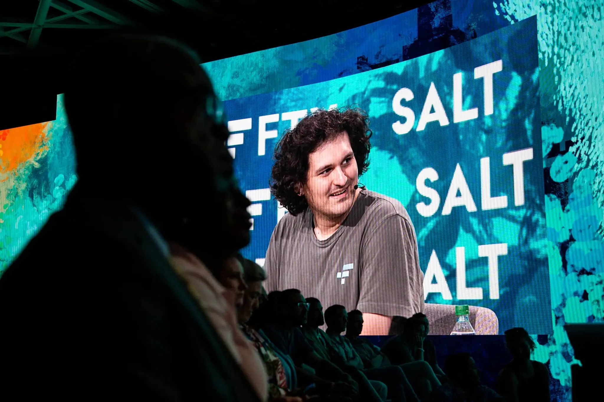 Sam Bankman-Fried på scen framför en skylt med texten Salt